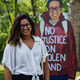 One of the community members stands with the portrait she inspired. It reads, “No justice on stolen land.”